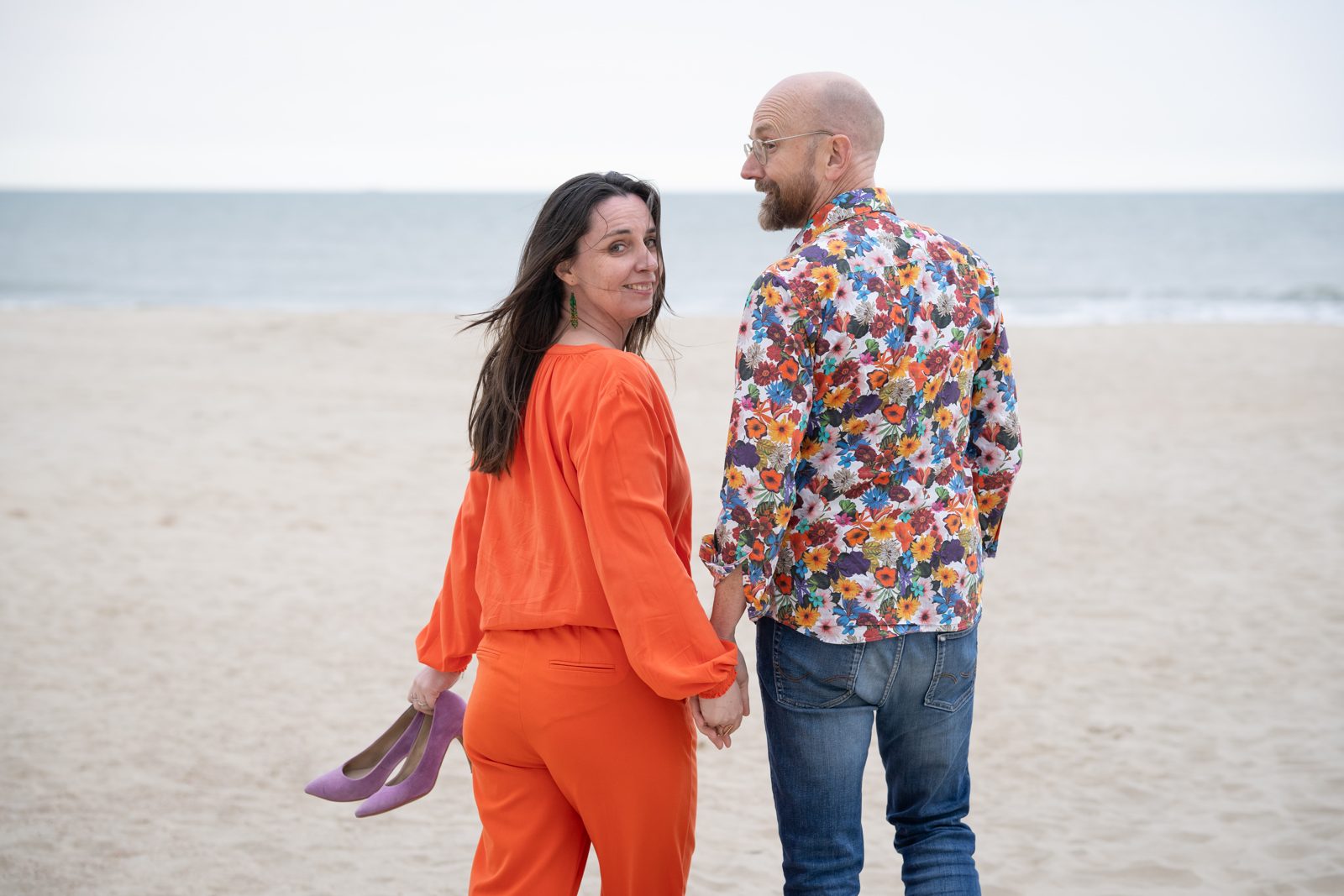 Liese and Alexander on the beach, looking back over their shoulders