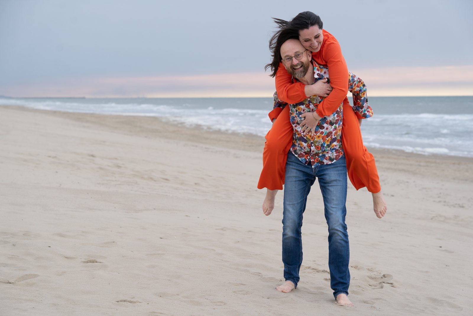 Liese on Alexander's back, laughing together on the beach